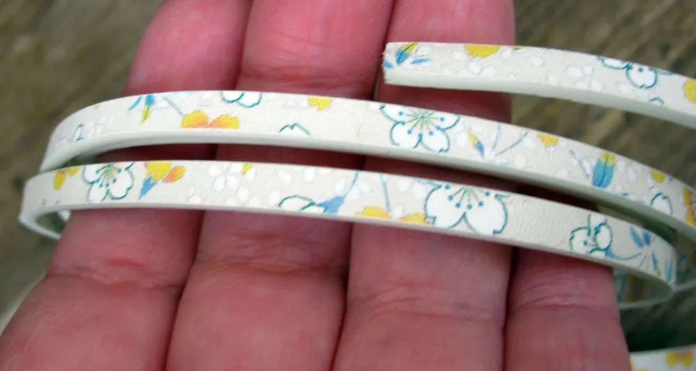 Läderimitation platt bred 5mm - Pärla med blommor, dubbelsidig 1,2 m