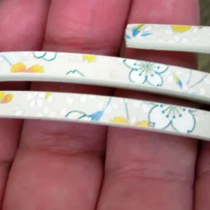 Läderimitation platt bred 5mm - Pärla med blommor, dubbelsidig 1,2 m
